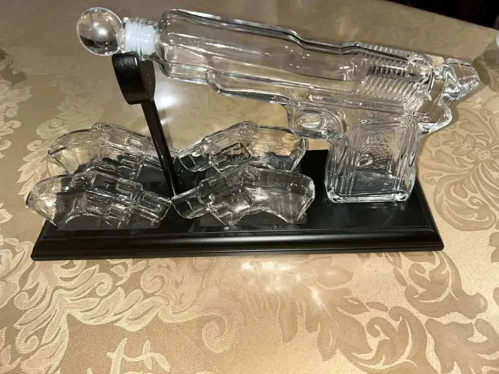 Clear Glass Pistol Decanter Set with Four Glass Shot Glasses on Display Stand